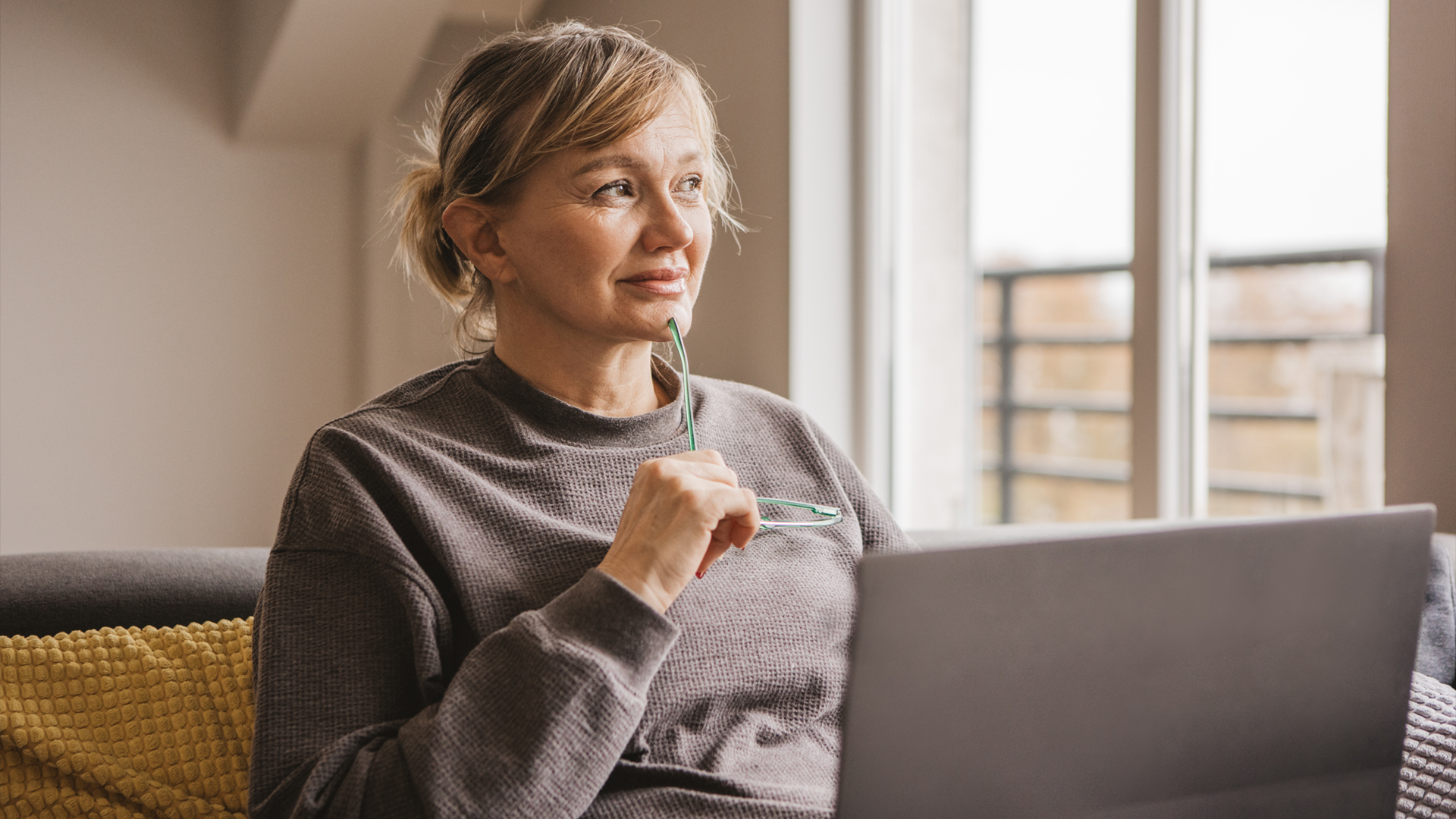 Une femme s’informe sur les symptômes de la ménopause sur son ordinateur portable