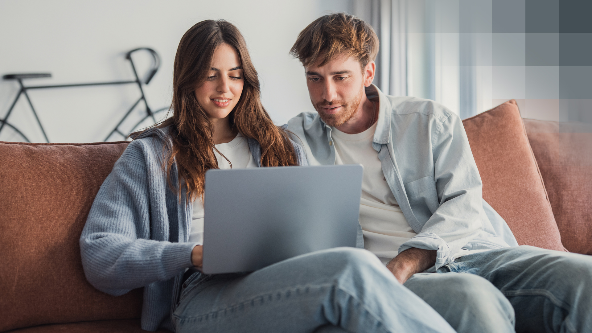 Un couple cherche sur un ordinateur portable l’assurance maladie suisse la moins chère
