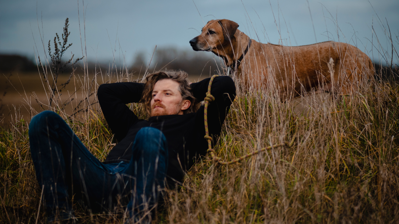 Ein Mann sitzt draussen in der Natur, um Stress abzubauen