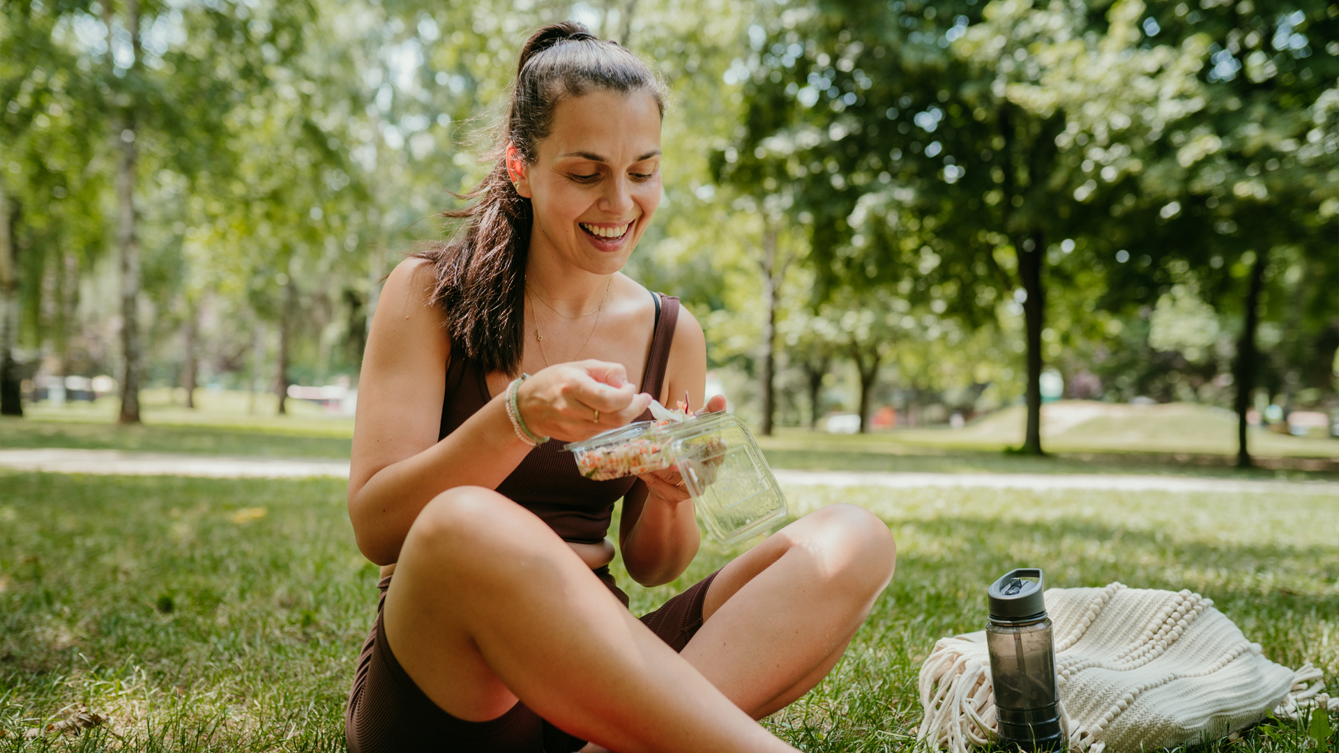 Femme dans un parc mangeant sainement pour prévenir le diabète et rester en bonne santé.