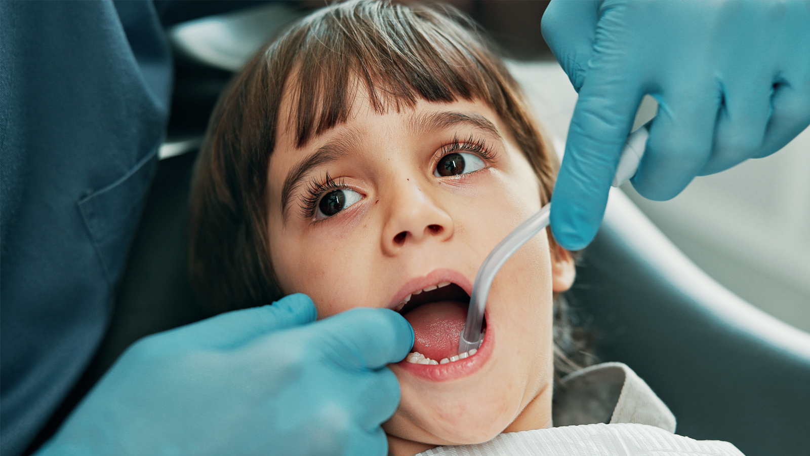 Une dentiste examine la dentition d'un jeune enfant à la recherche de caries.