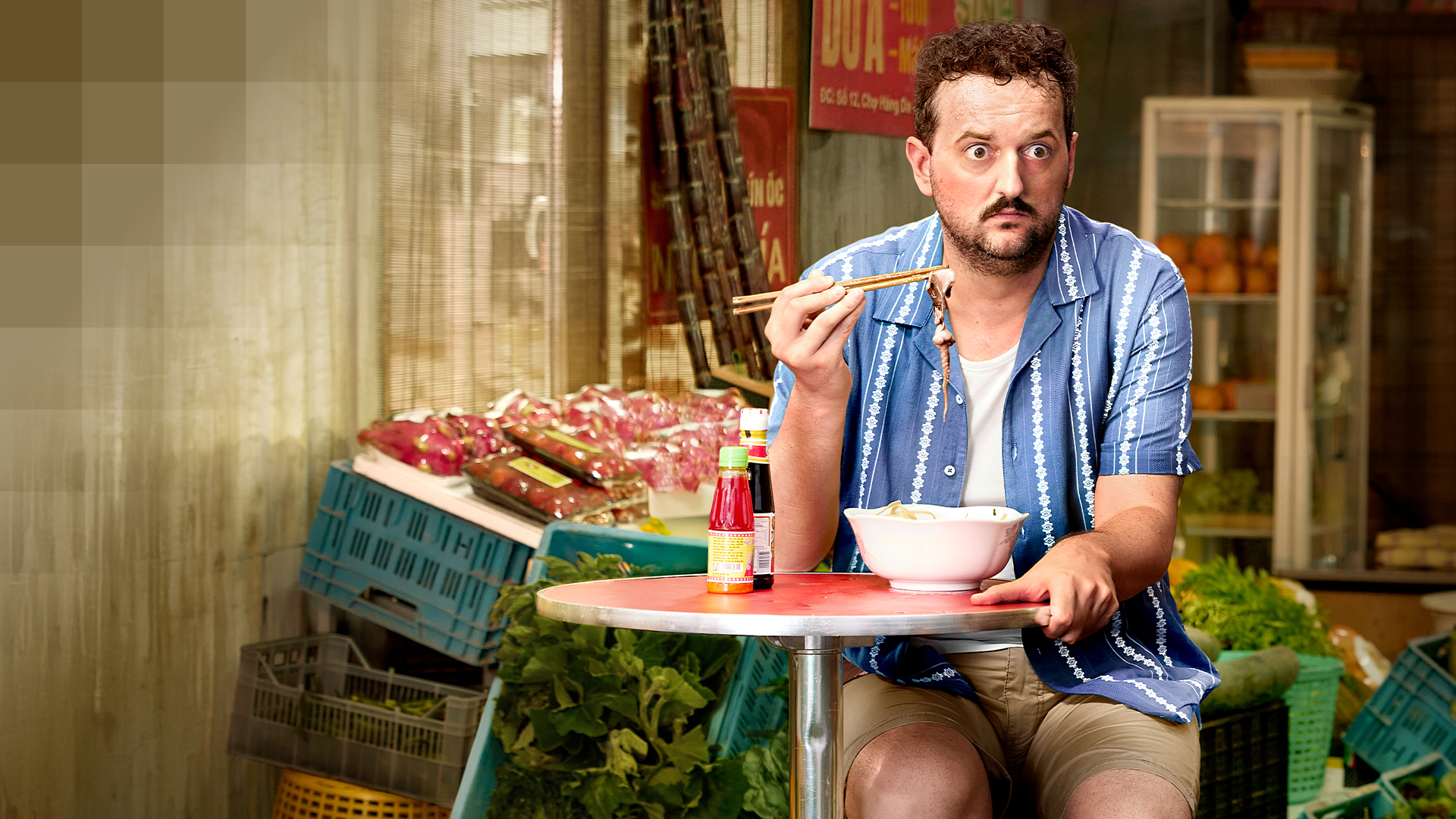 Un uomo dall'aria preoccupata che mangia in un mercato di street food – coperto da un'assicurazione complementare ospedaliera privata.